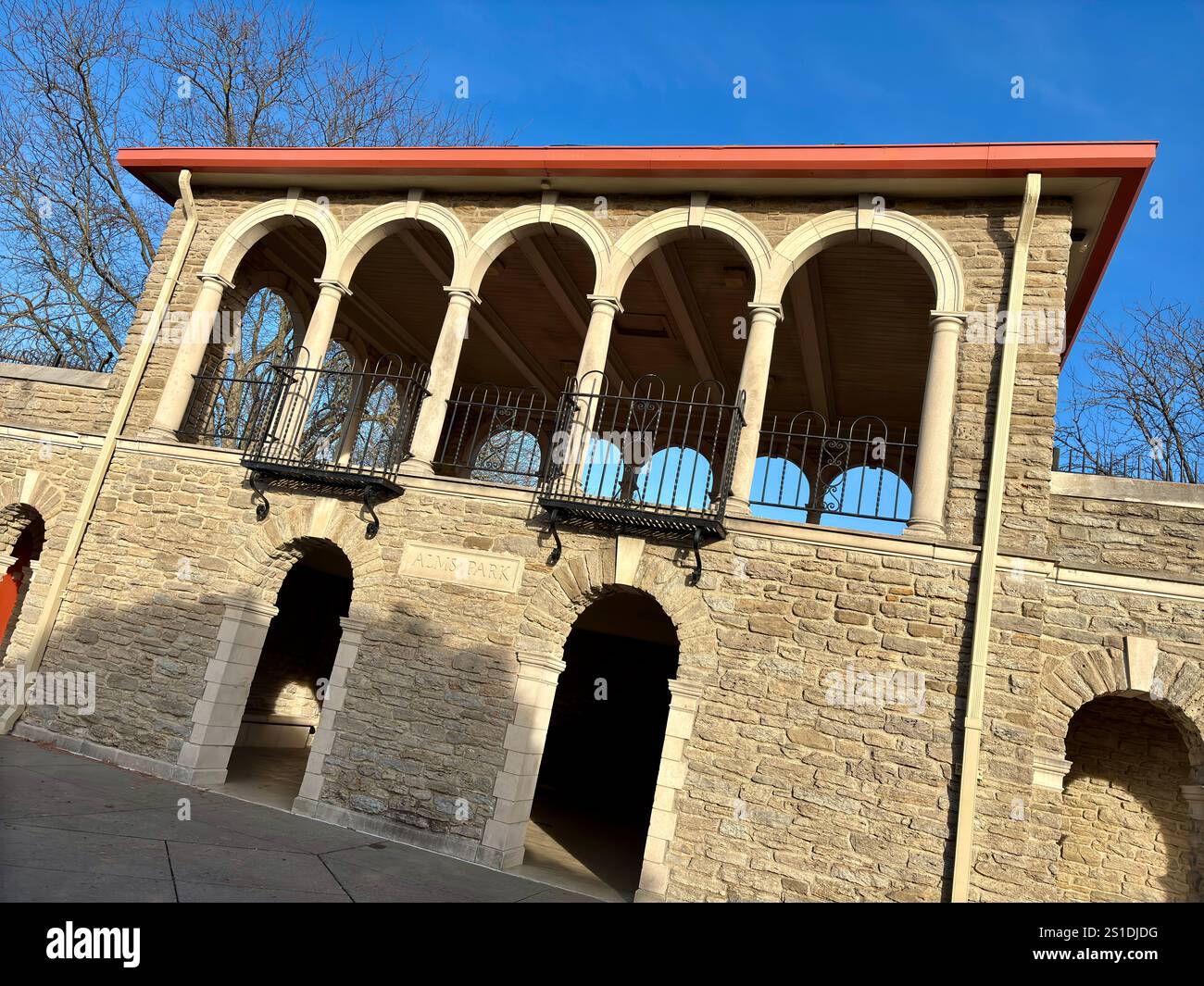 Bâtiment en pierre avec fenêtres cintrées, balcons, ciel bleu clair Banque D'Images