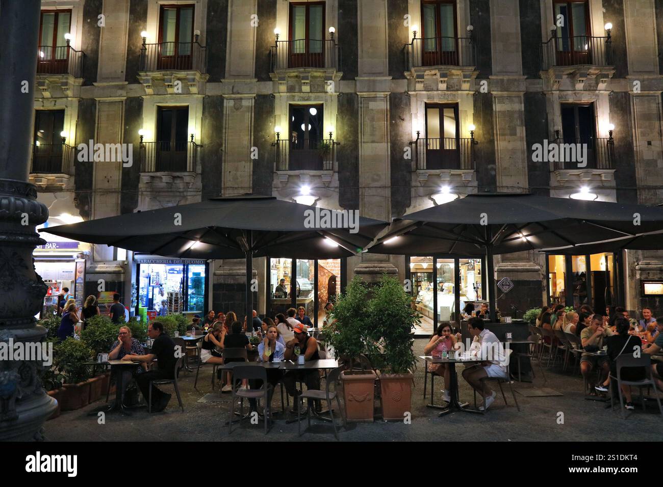 CATANE, ITALIE - 8 AOÛT 2024 : les gens visitent les restaurants de la place Piazza Duomo le soir dans la ville de Catane sur l'île de Sicile, en Italie. Banque D'Images