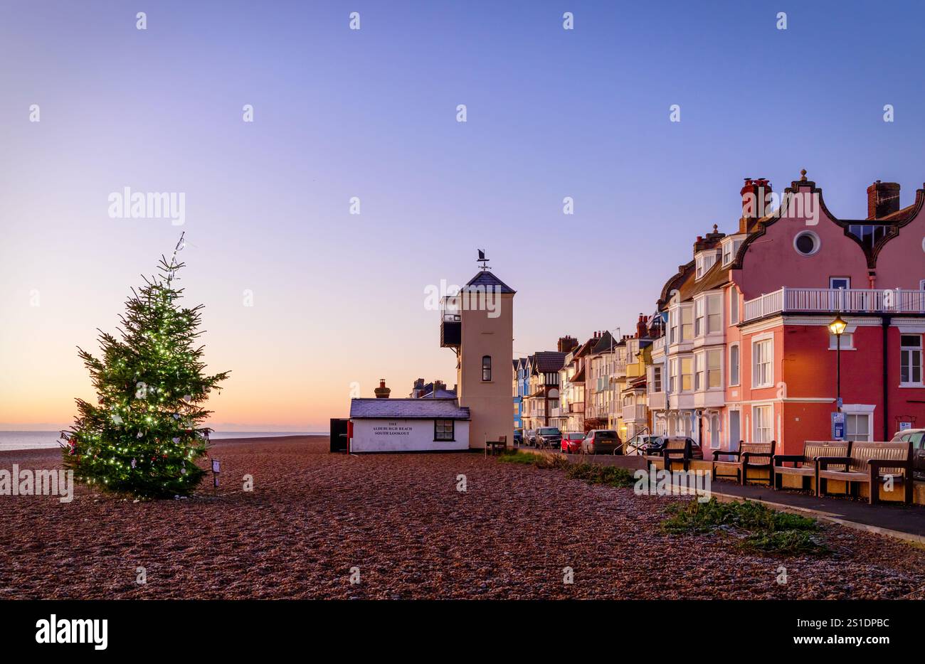 Vue sur le front de mer d'Aldeburgh au lever du soleil, avec l'arbre de Noël Memorial au premier plan. Banque D'Images