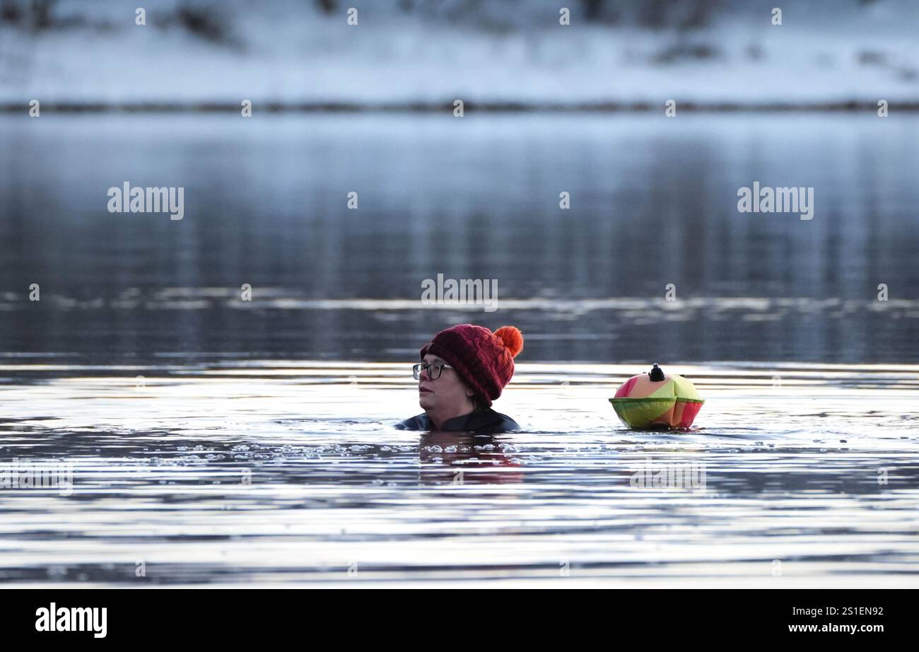 Un nageur au réservoir Harlaw dans les collines Pentland, Balerno, Édimbourg. L'Agence britannique de sécurité sanitaire (UKHSA) a émis des alertes sanitaires par temps froid pour toute l'Angleterre avant une semaine de basses températures. Des alertes AMBER ont été émises à partir de 12 heures jeudi jusqu'au 8 janvier, ce qui signifie qu'une augmentation des décès, en particulier parmi les personnes âgées de 65 ans et plus ou souffrant de problèmes de santé, est probable, a déclaré l'UKHSA. Date de la photo : vendredi 3 janvier 2025. Banque D'Images