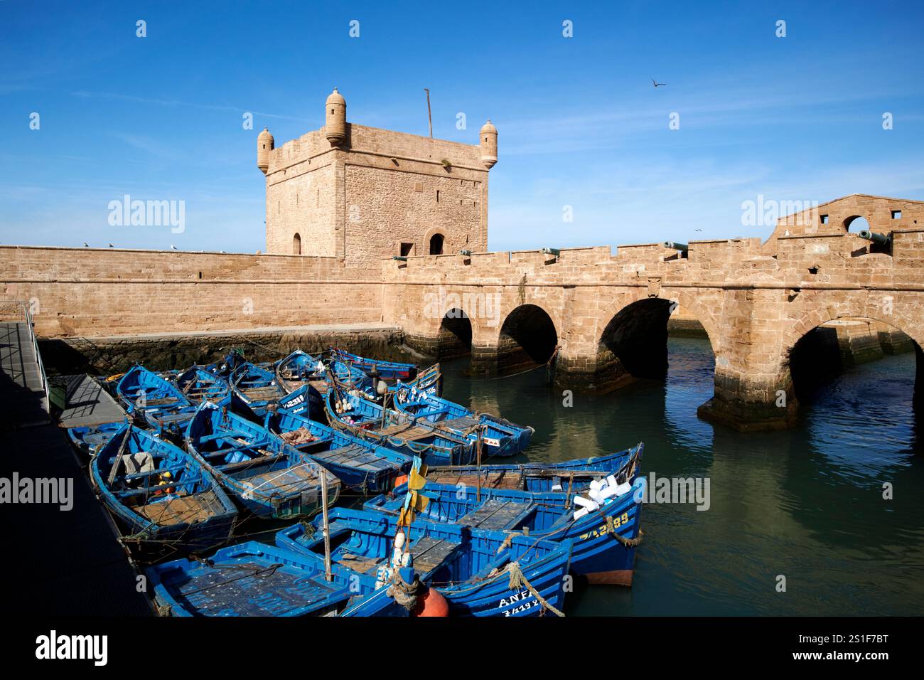 bateaux de pêche traditionnels en bois peints en bleu devant le skala du port et les fortifications portuaires essaouira, maroc Banque D'Images
