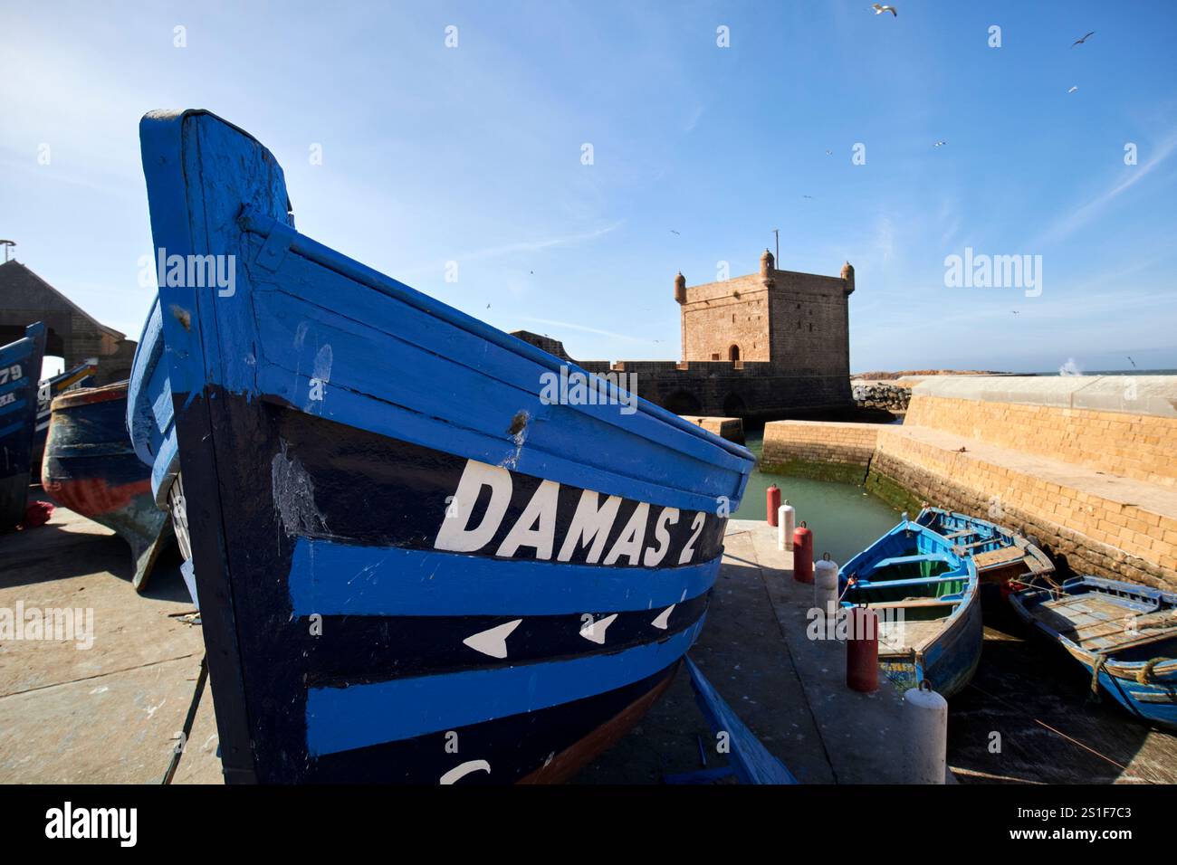 bateau de pêche traditionnel en bois peint en bleu devant le skala du port essaouira, maroc Banque D'Images