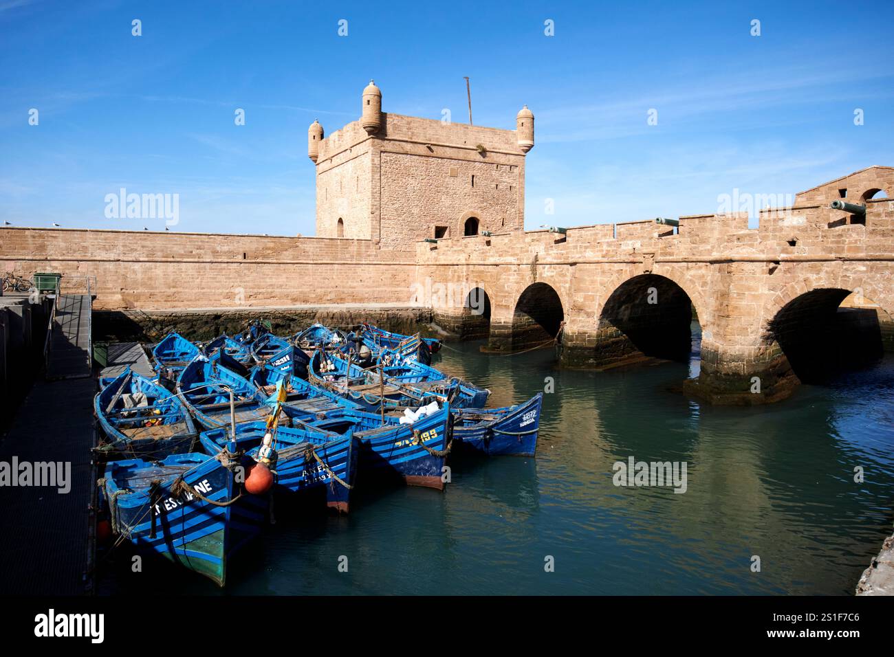 bateaux de pêche traditionnels en bois peints en bleu devant le skala du port et les fortifications portuaires essaouira, maroc Banque D'Images