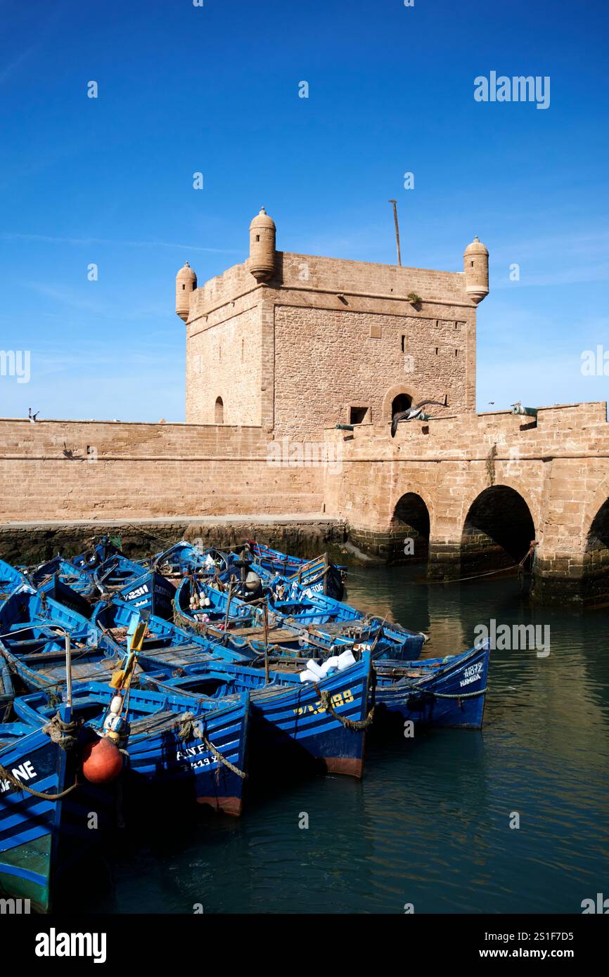 bateaux de pêche traditionnels en bois peints en bleu devant le skala du port et les fortifications portuaires essaouira, maroc Banque D'Images