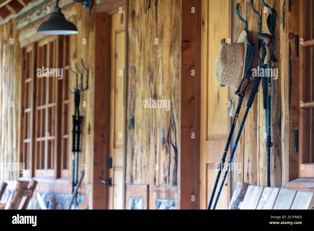 Bâtons de randonnée et chapeau accroché sur le porche d'une cabane au Minam River Lodge, Oregon. Banque D'Images