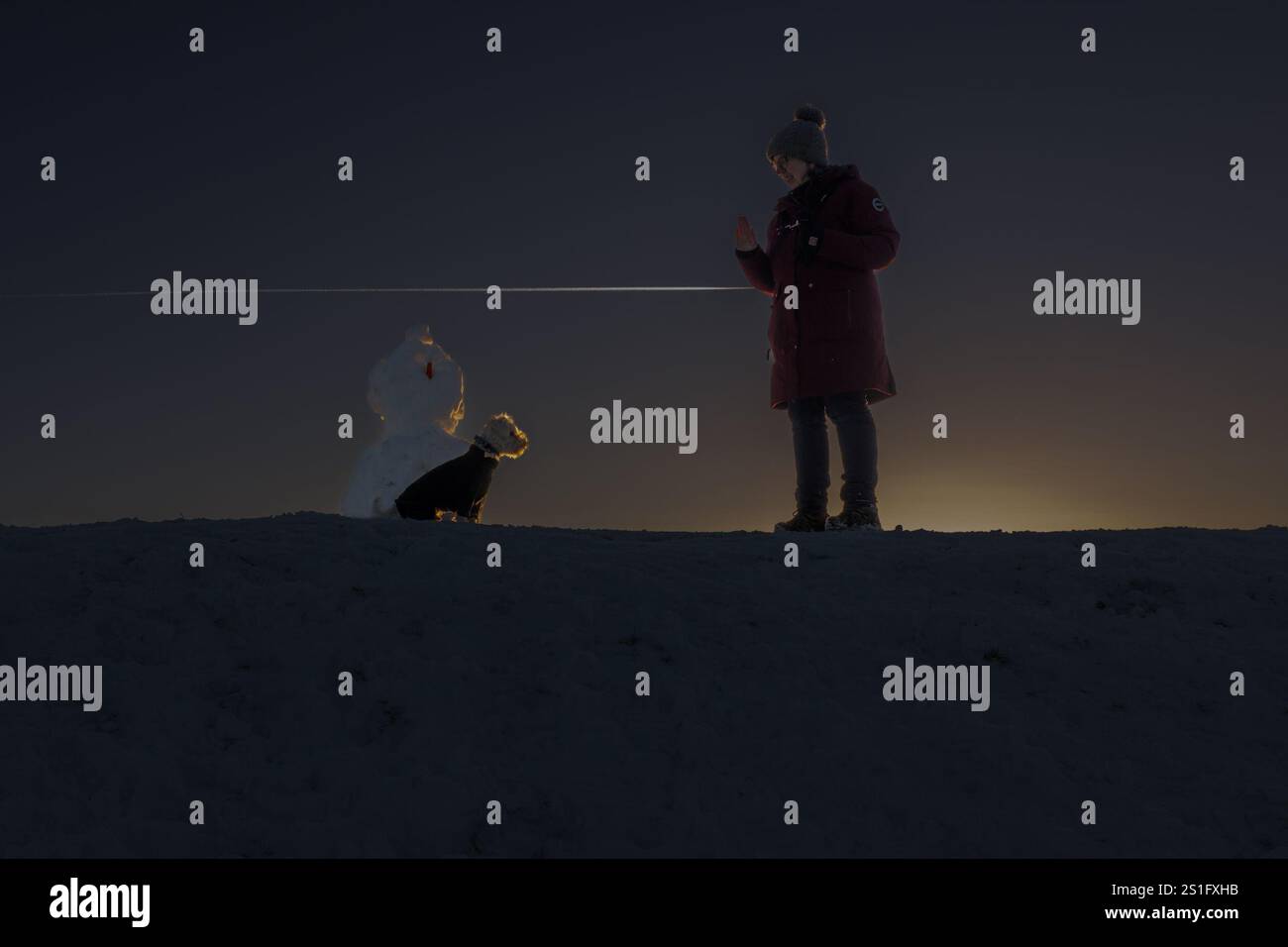 Harlaw. Balerno. Midlothian. Écosse, Royaume-Uni. 3 janvier 2025. Alors que je montais une colline au réservoir Harlaw près de Balerno dans le Midlothian, j'ai vu un bonhomme de neige et Monty le schnoodle avec le propriétaire Andrea. J'ai pris un coup de pouce et il s'est avéré que le soleil se couchait juste et a fait une silhouette affectueuse (crédit photo : David Mollison/Alamy Live News Banque D'Images