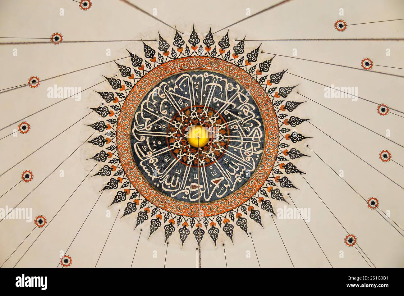 Médaillon du dôme de la mosquée Rustem Pacha calligraphie Istanbul // ISTANBUL, Turquie — le médaillon central du dôme principal de la mosquée Rustem Pacha présente une peinture décorative ottomane complexe et une calligraphie. Créée en 1563 lors de la construction de la mosquée, cette pièce maîtresse combine motifs géométriques, motifs floraux et calligraphie arabe dans le style ottoman classique. La conception illustre les réalisations artistiques sophistiquées des artisans ottomans pendant le règne de Suleiman le magnifique. Conçue par le maître architecte Mimar Sinan, la mosquée est réputée pour son utilisation intensive de la tiée d'Iznik Banque D'Images