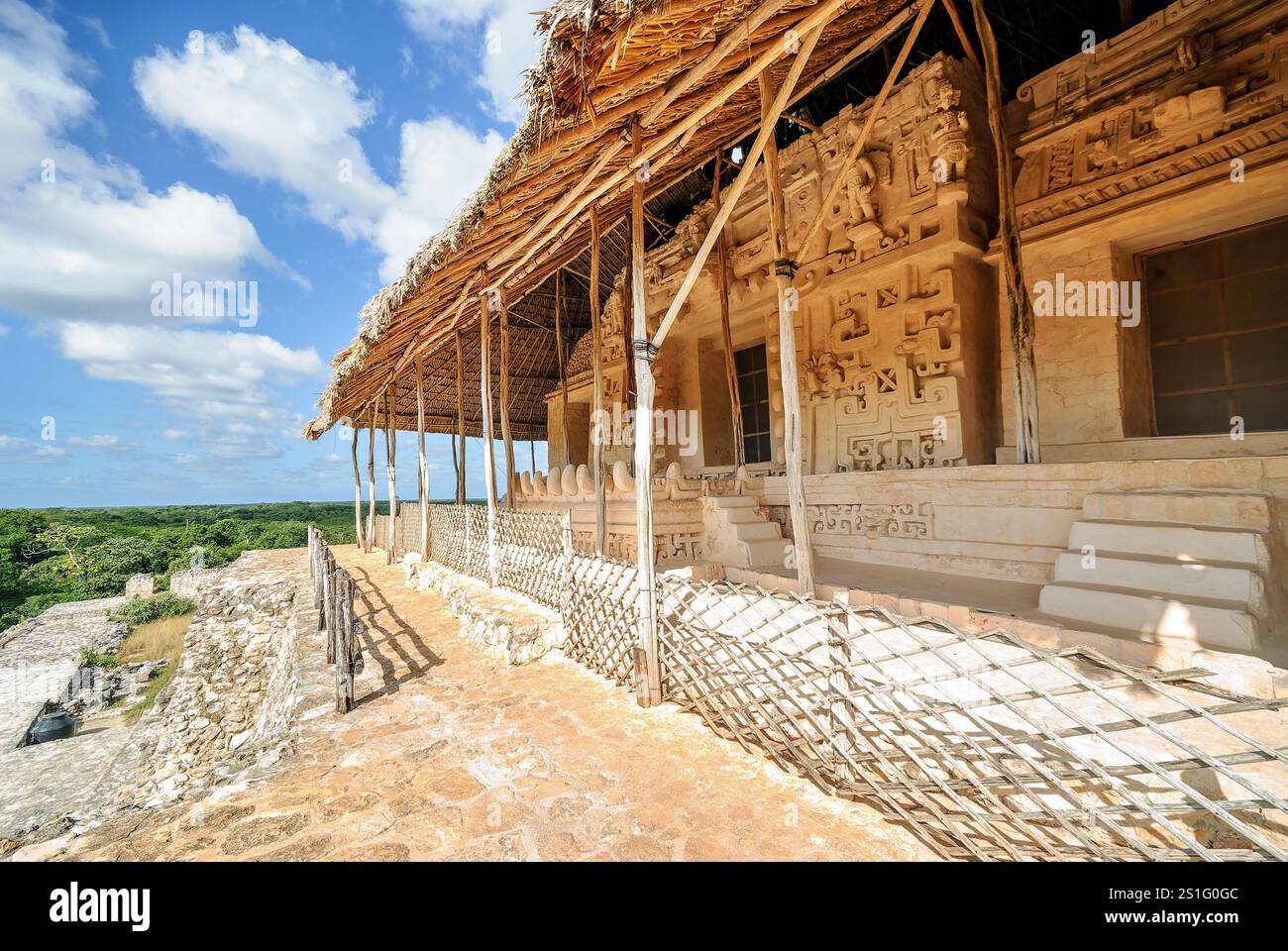 Décoration en stuc EK Balam Acropolis Yucatan Mexique // EK' BALAM, Mexique — la décoration en stuc élaborée à l'extérieur de l'Acropole présente des détails sculpturaux complexes maintenant protégés par une couverture de toit de chaume. La façade ornée entourant le tombeau d'Ukit Kan le'k Tok' présente des techniques artistiques mayas sophistiquées de la période classique tardive, avec une construction multicouche en stuc à la chaux construite plutôt que sculptée dans la pierre. Ek' Balam (également connu sous le nom d'Ek Balam) a atteint son apogée entre 770-840 EC en tant que capitale de l'ancien Royaume maya de Talol. Le site est situé au Mexique Banque D'Images