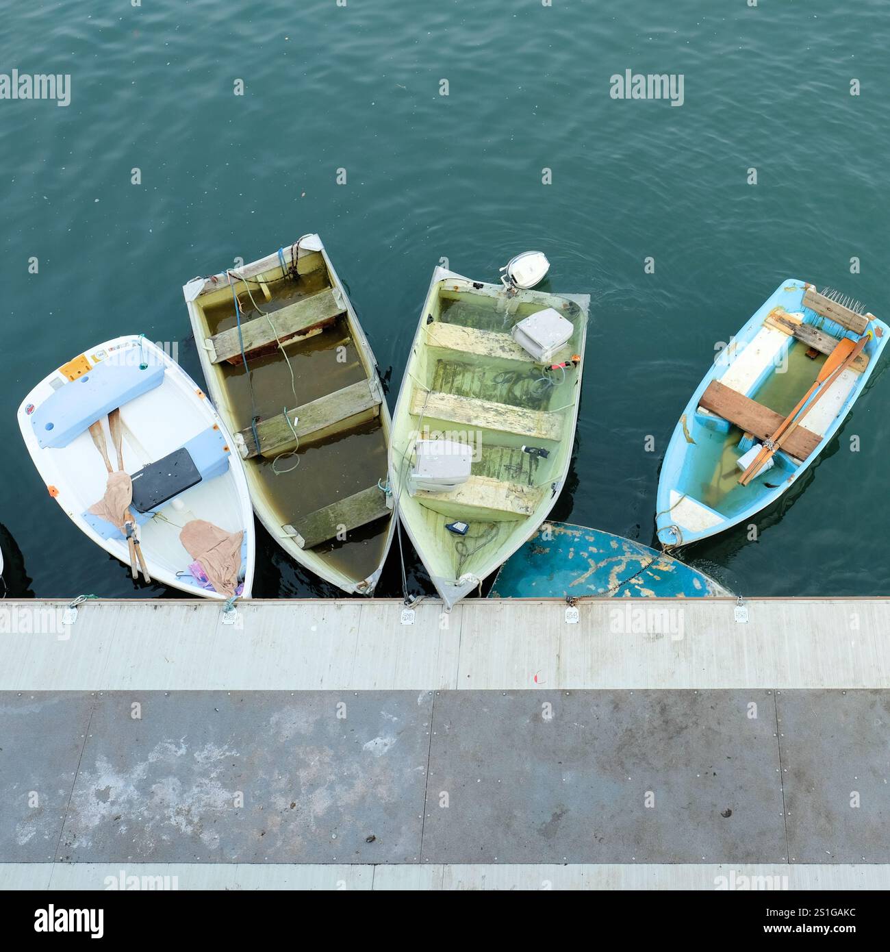 Bateaux à rames amarrés remplis d'eau de pluie après une tempête de pluie près de la marina et des quais de Monterey, en Californie ; prendre l'eau d'une tempête. Banque D'Images