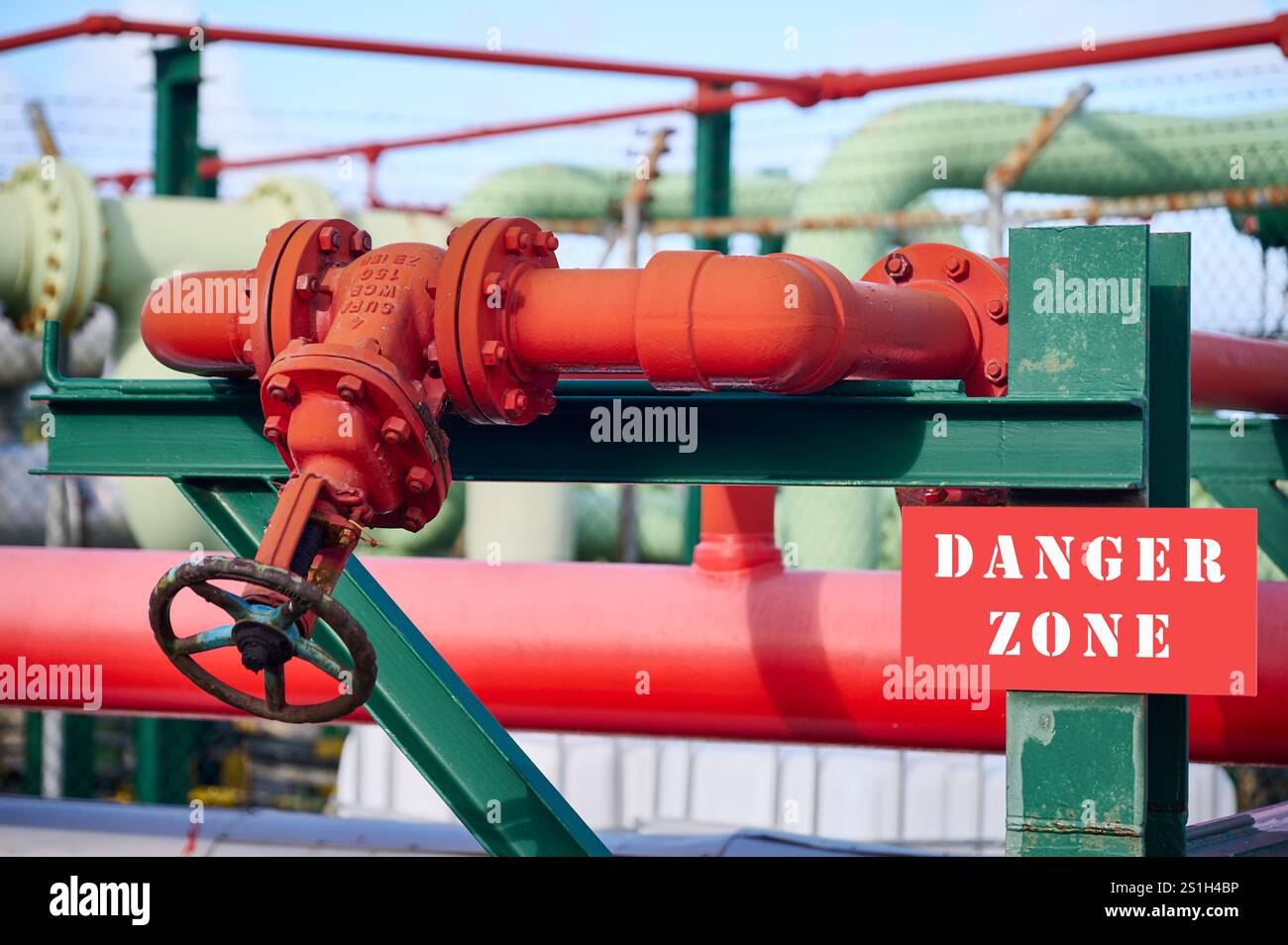 Vanne industrielle sur une ligne de tuyaux peints en rouge, zone de danger Banque D'Images