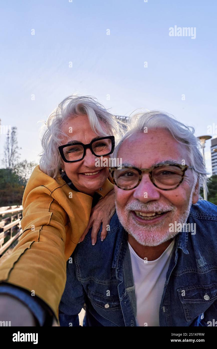 Heureux couple senior caucasien prenant un selfie à l'extérieur ensemble, profitant de la vie à la retraite et de l'amour. Banque D'Images