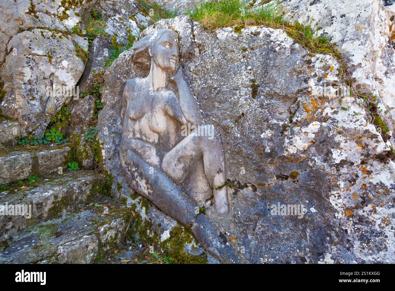 Sculpture en pierre de figure couchée avec mousse et végétation à Cervara di Roma Banque D'Images