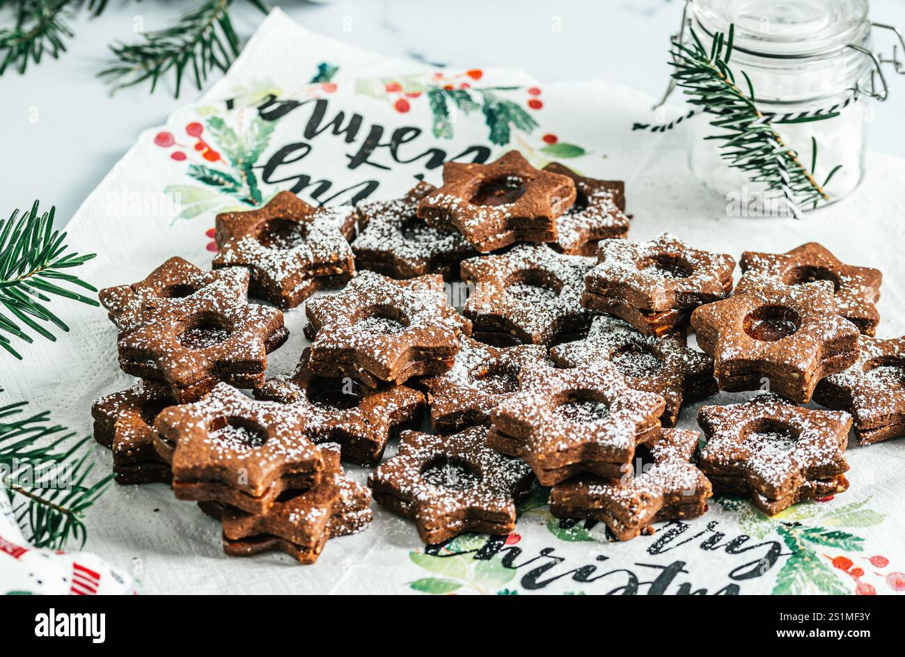 Biscuits de Noël Linz traditionnels remplis de confiture de coing sur fond blanc. Décorer avec des branches de sapin. Banque D'Images