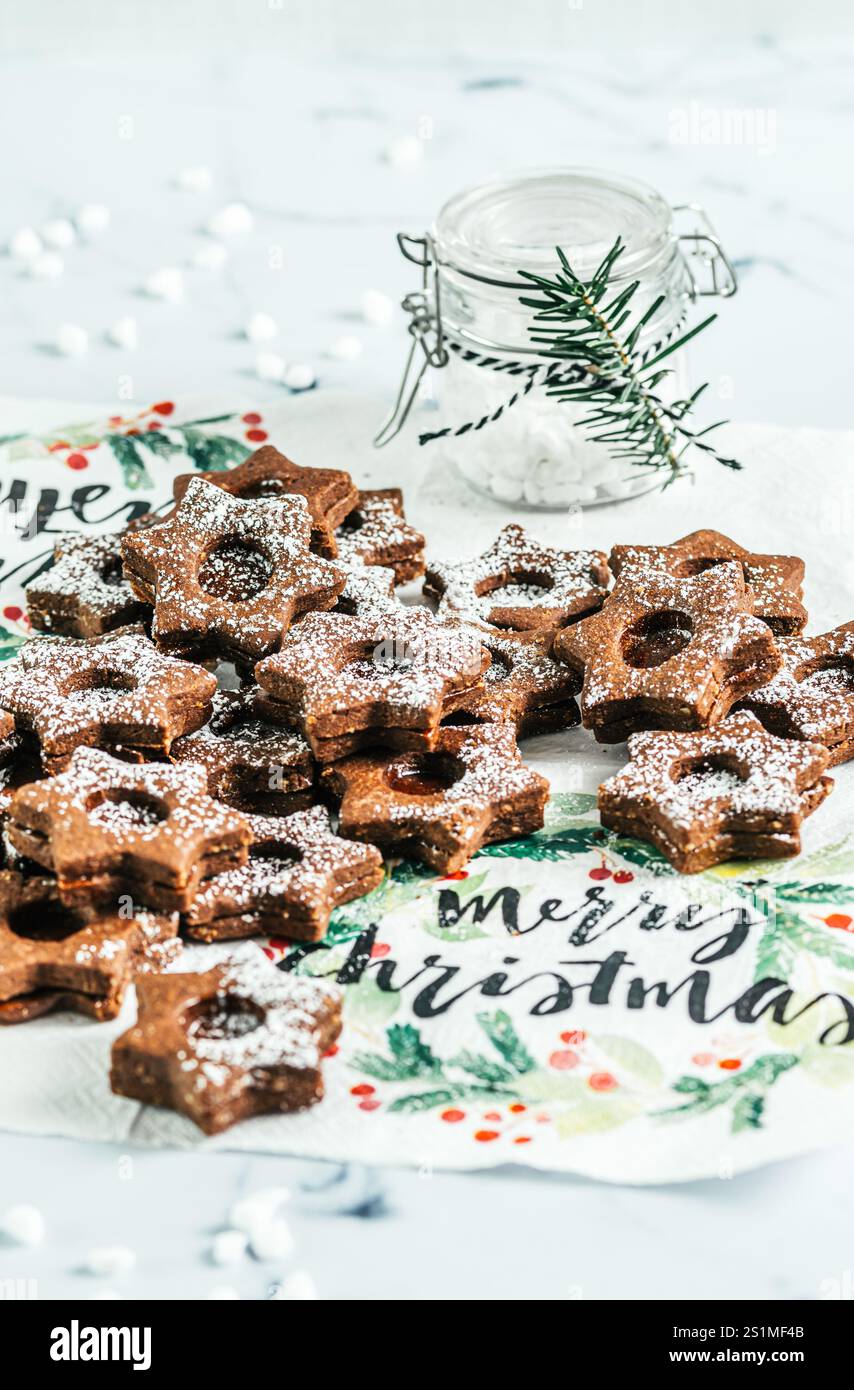 Biscuits de Noël Linz traditionnels remplis de confiture de coing sur fond blanc. Décorer avec des branches de sapin. Banque D'Images