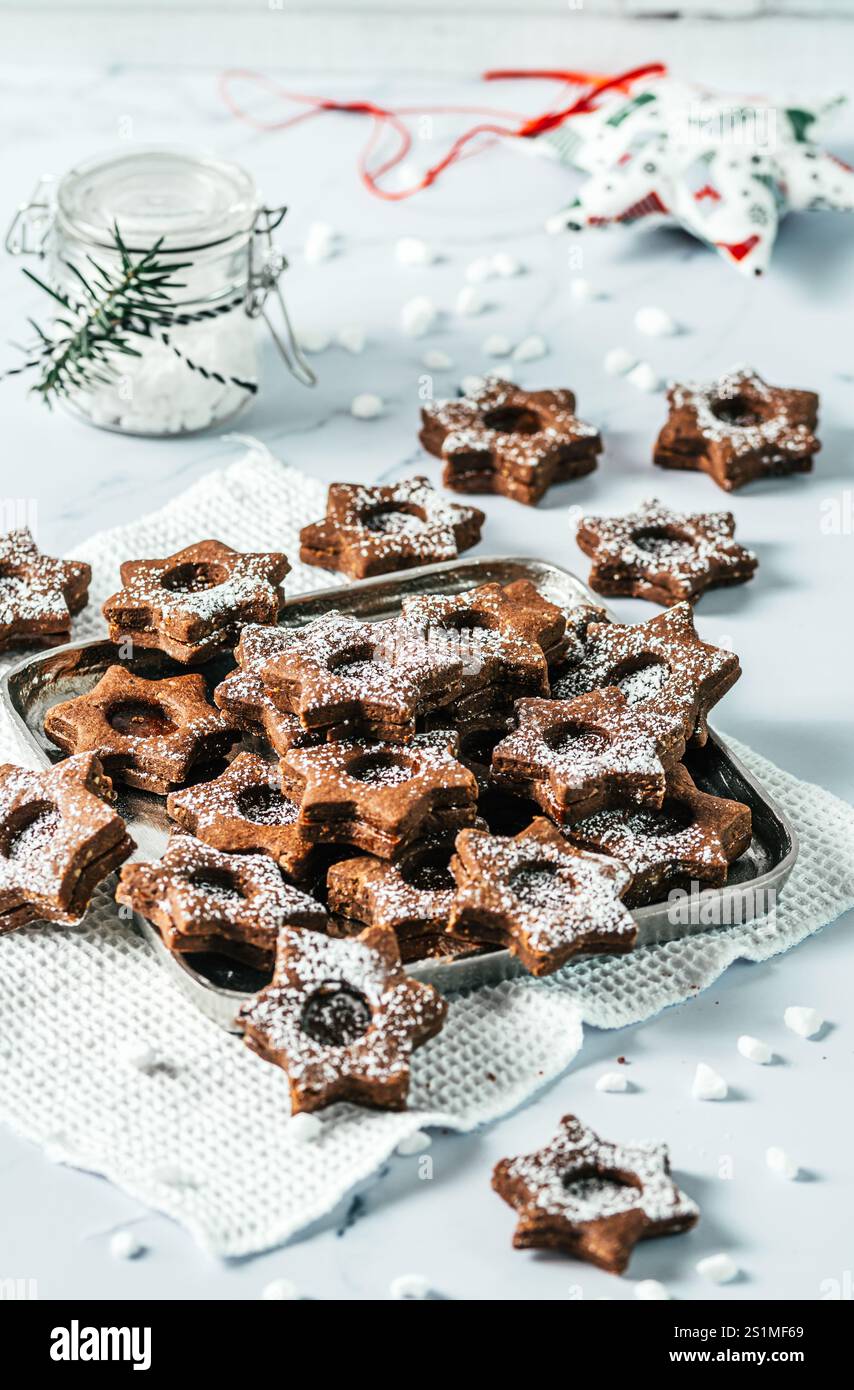 Biscuits de Noël Linz traditionnels remplis de confiture de coing sur fond blanc. Décorer avec des branches de sapin. Banque D'Images