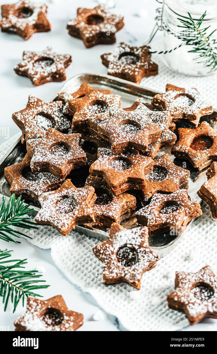 Biscuits de Noël Linz traditionnels remplis de confiture de coing sur fond blanc. Décorer avec des branches de sapin. Banque D'Images