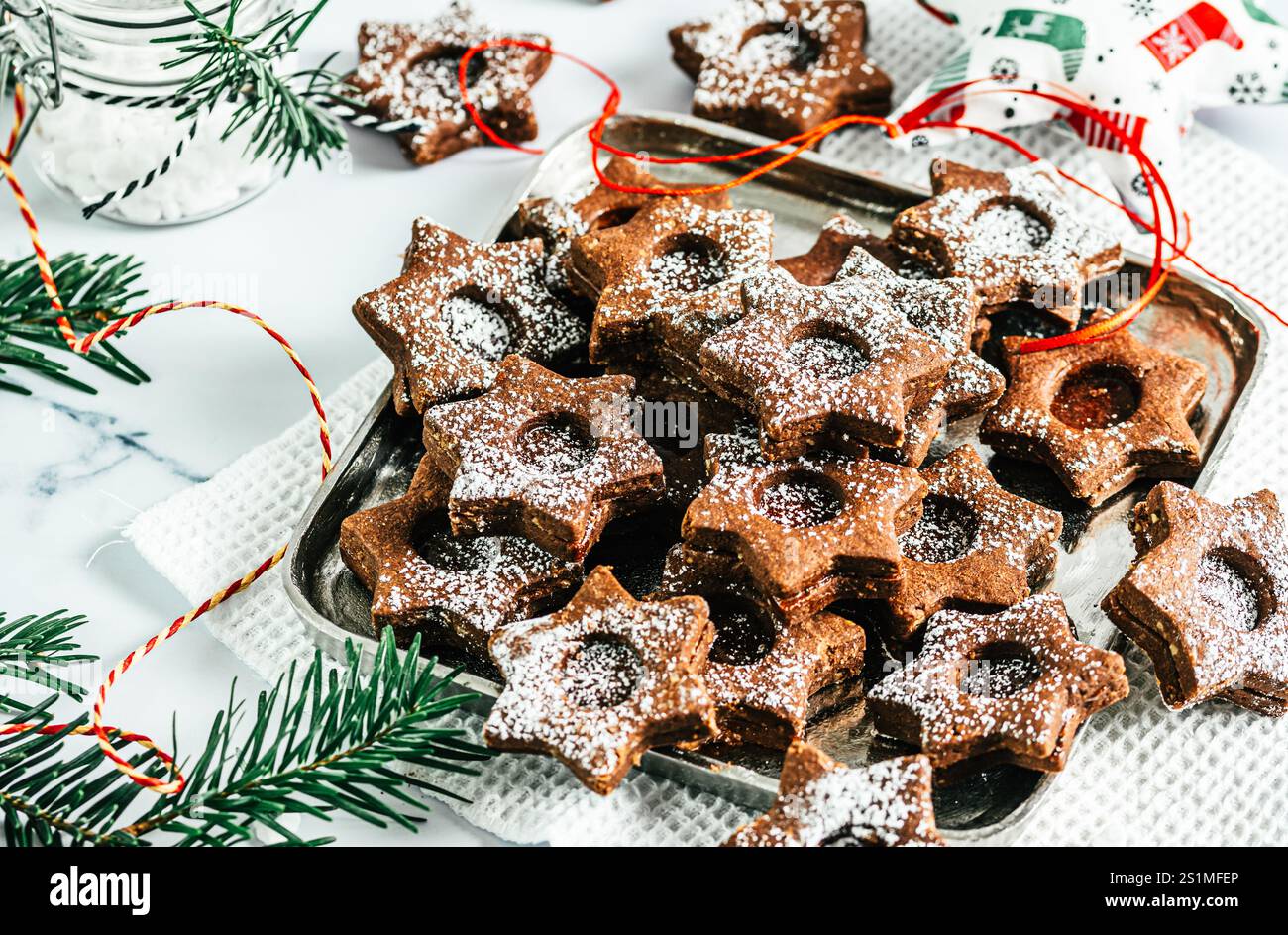 Biscuits de Noël Linz traditionnels remplis de confiture de coing sur fond blanc. Décorer avec des branches de sapin. Banque D'Images
