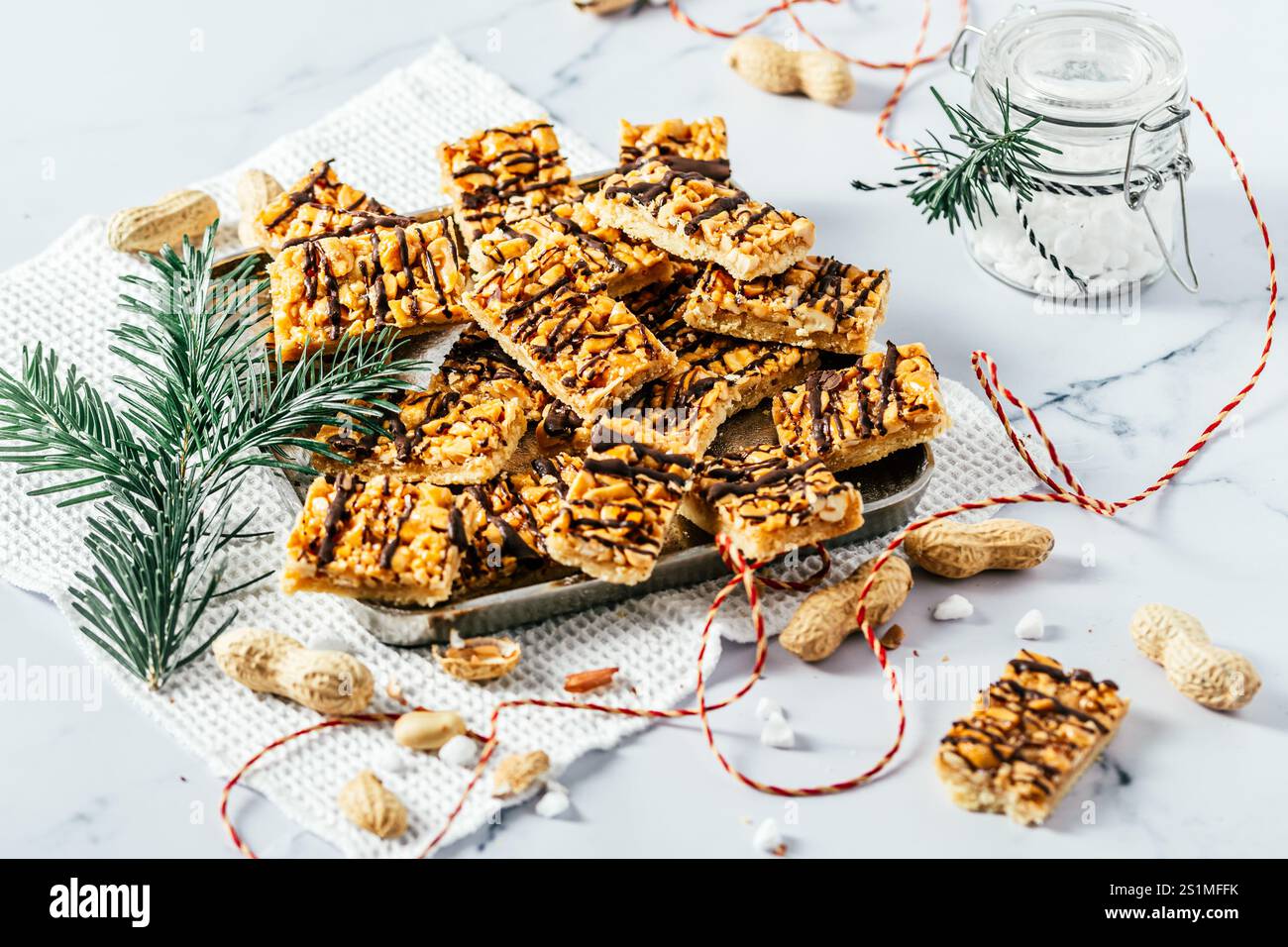 Biscuits au caramel aux arachides faits maison, biscuits de Noël au caramel salé et aux arachides, coupés en rectangles, fond blanc Banque D'Images