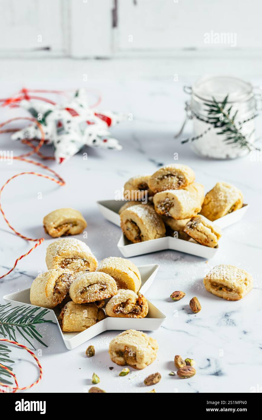 Biscuits de pâte brisée avec remplissage à la pistache, cuisson de Noël, rouleaux de pistache sur fond blanc, vertical Banque D'Images