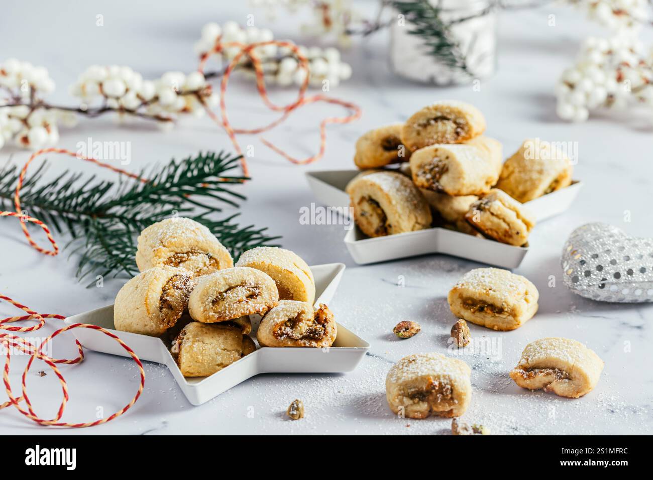 Biscuits de pâte brisée avec remplissage à la pistache, cuisson de Noël, rouleaux de pistache sur fond blanc Banque D'Images