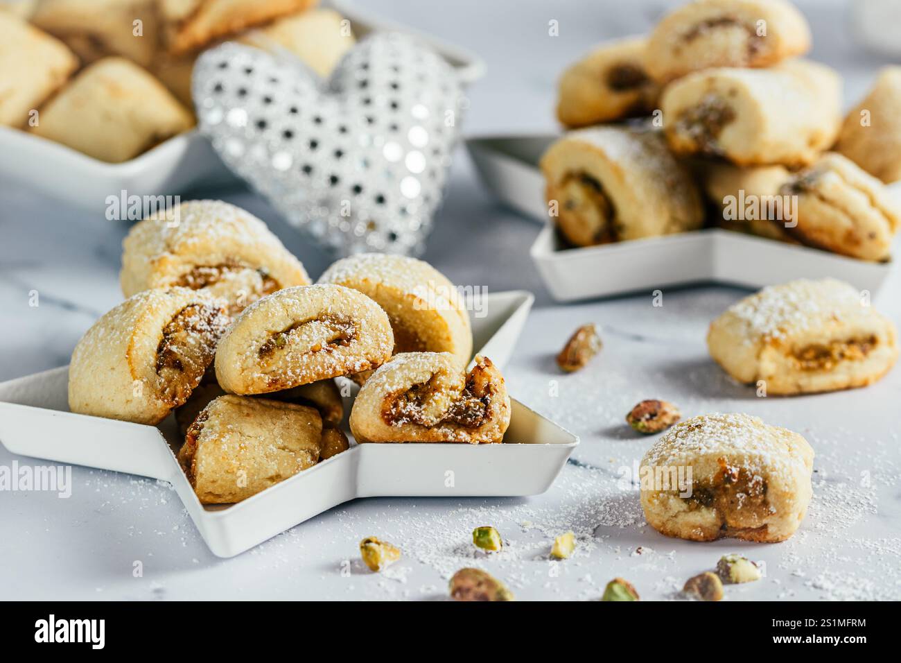Biscuits de pâte brisée avec remplissage à la pistache, cuisson de Noël, rouleaux de pistache sur fond blanc Banque D'Images