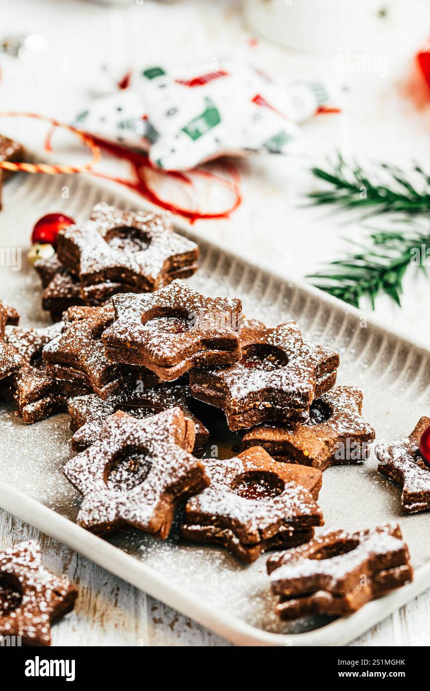 Biscuits de Noël Linz traditionnels remplis de confiture de coing sur fond blanc en bois, décoration christmale, verticale Banque D'Images