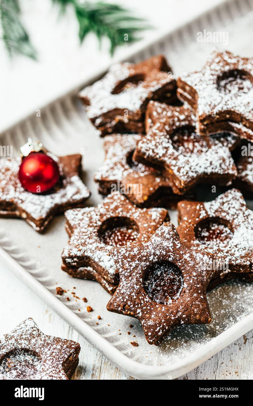 Biscuits de Noël Linz traditionnels remplis de confiture de coing sur fond blanc en bois, décoration christmale, verticale Banque D'Images