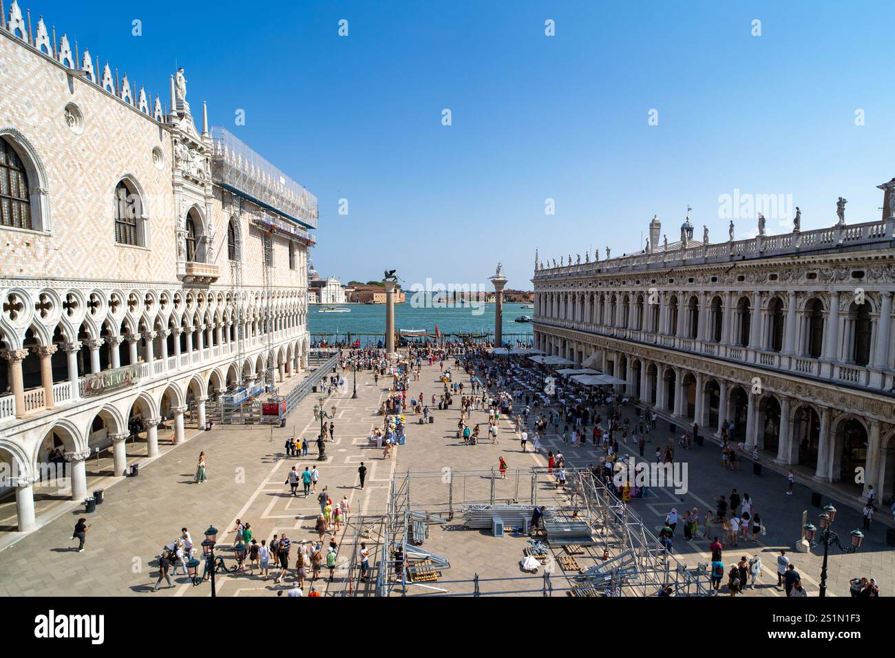Le Palais des Doges à Venise, en Italie, présente une architecture gothique complexe avec des fenêtres cintrées et des détails ornés. Les touristes se rassemblent le long du Waterfro Banque D'Images