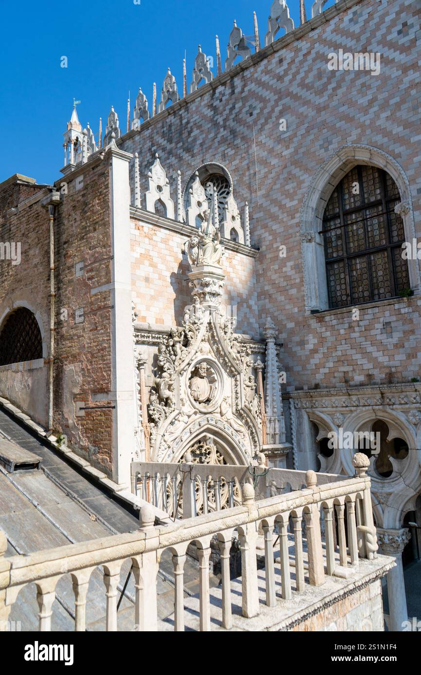 Le Palais des Doges à Venise, en Italie, présente une architecture gothique complexe avec des fenêtres cintrées et des détails ornés. Les touristes se rassemblent le long du Waterfro Banque D'Images