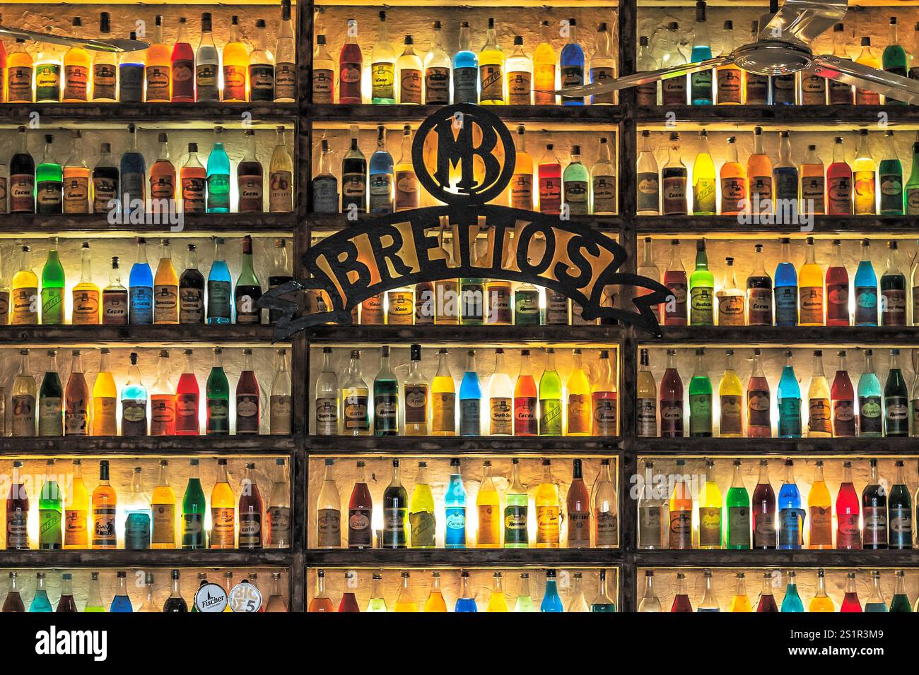 Étagère vibrante de bouteilles colorées dans un bar avec éclairage au néon, Athènes, Grèce Banque D'Images