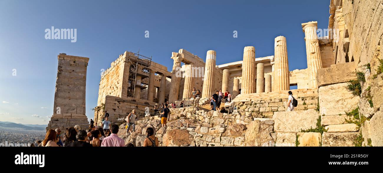 Entrée historique de l'Acropole sous ciel bleu clair avec des visiteurs explorant Athènes, Grèce Banque D'Images