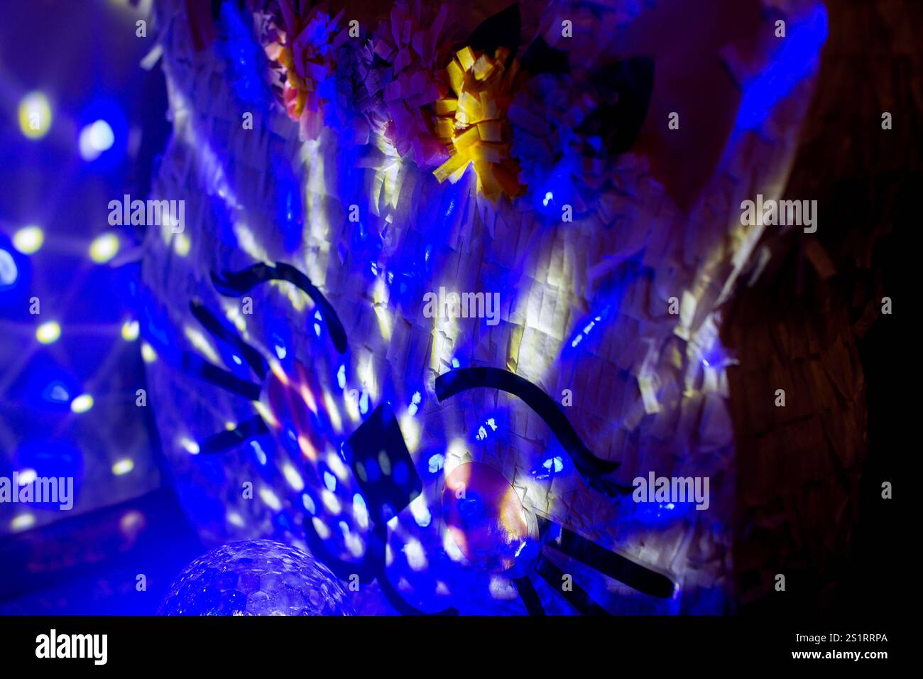Décoration Pinata visage de chat pour célébration d'anniversaire illuminée par des lumières bleues Banque D'Images