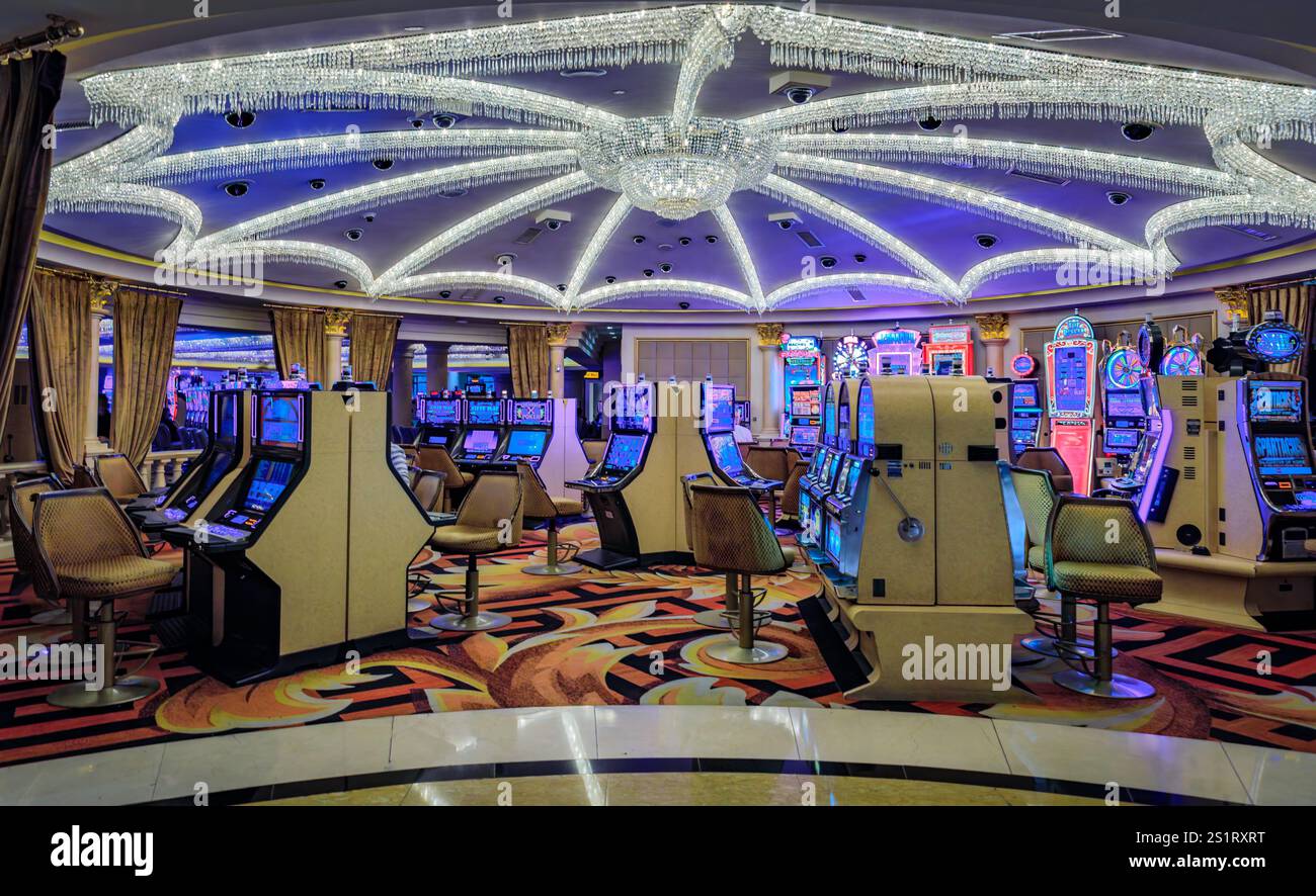Las Vegas, Nevada, États-Unis - 24 octobre 2021 : rangées de machines à sous et chaises vides sous un grand lustre orné dans le casino Caesars Palace Banque D'Images