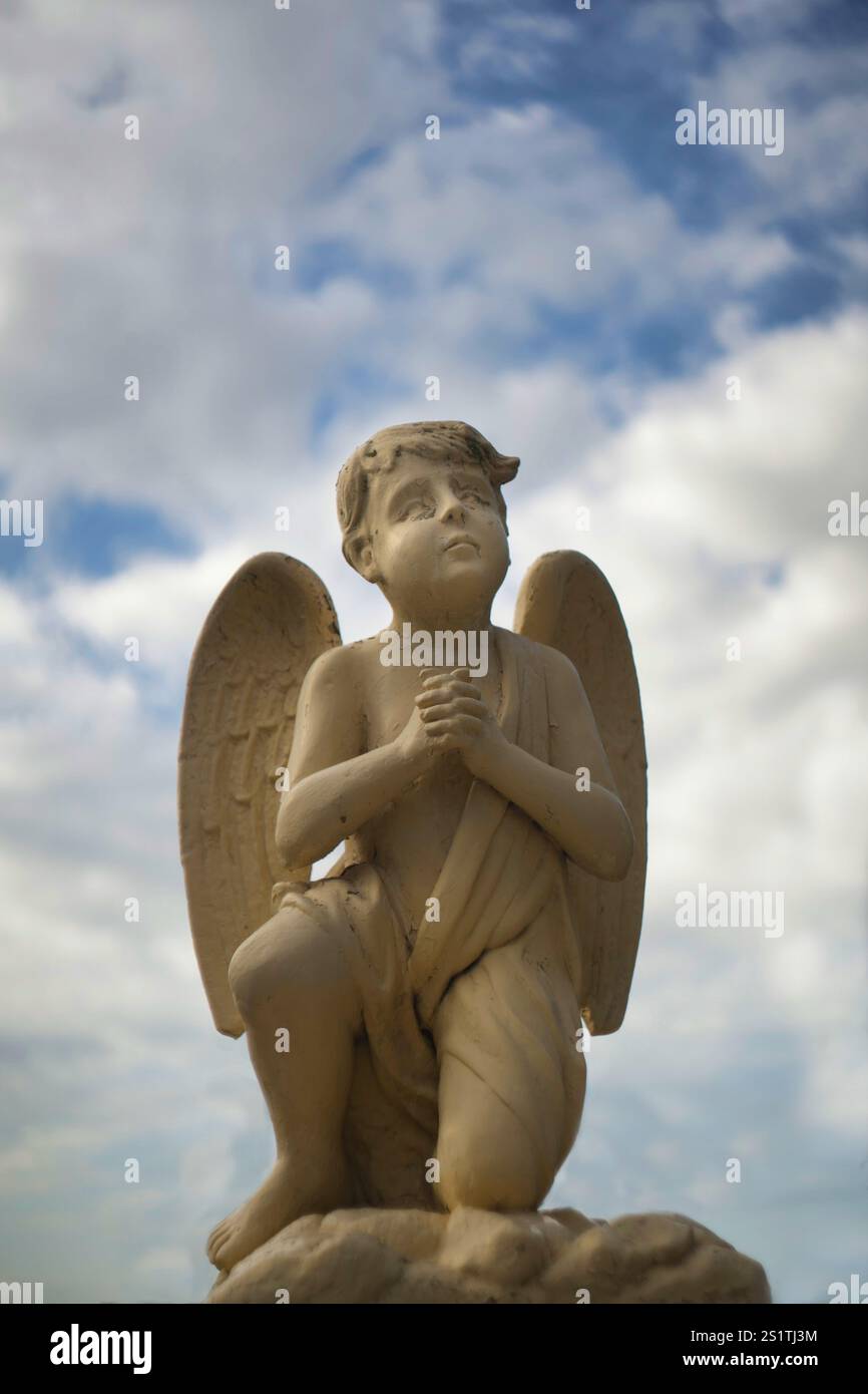 Statue d'un ange avec des ailes regardant vers le ciel, priant Banque D'Images