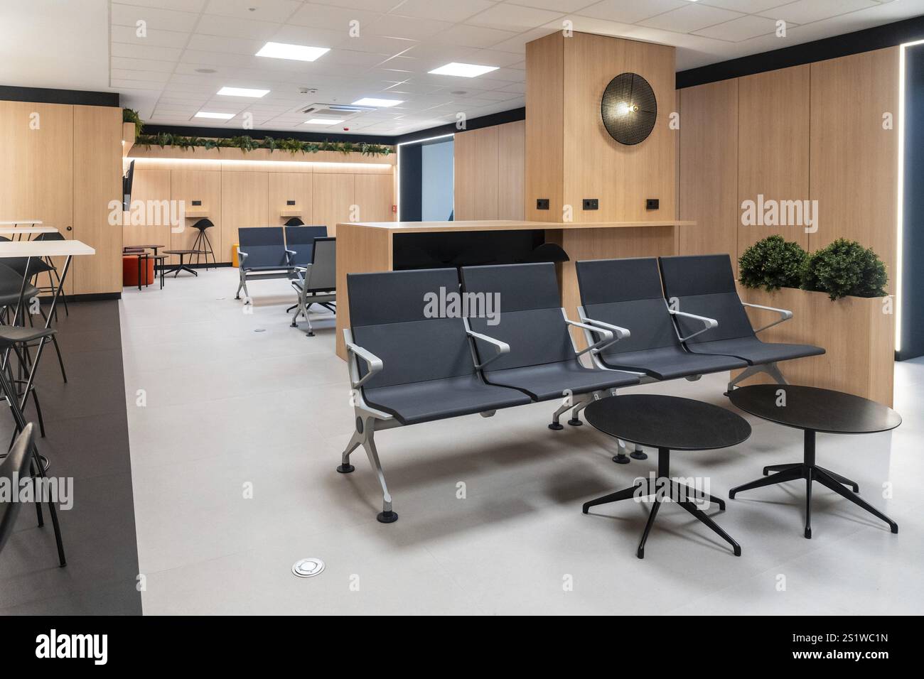 Une grande salle avec beaucoup de chaises et de tables. Les chaises sont noires et les tables sont noires Banque D'Images