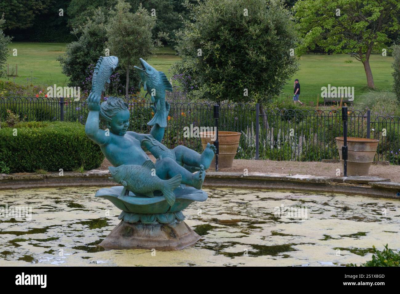Fontaine de bébé d'eau, statue de bronze dans un étang à Golders Hill Park, Golders Green, Londres. Banque D'Images