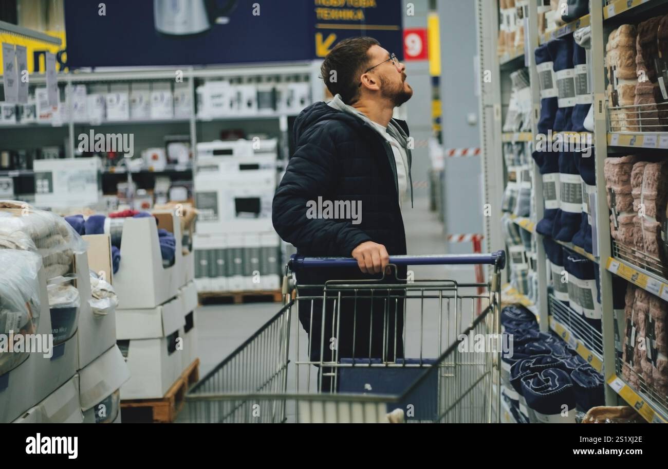 Un homme faisant du shopping dans un supermarché Banque D'Images