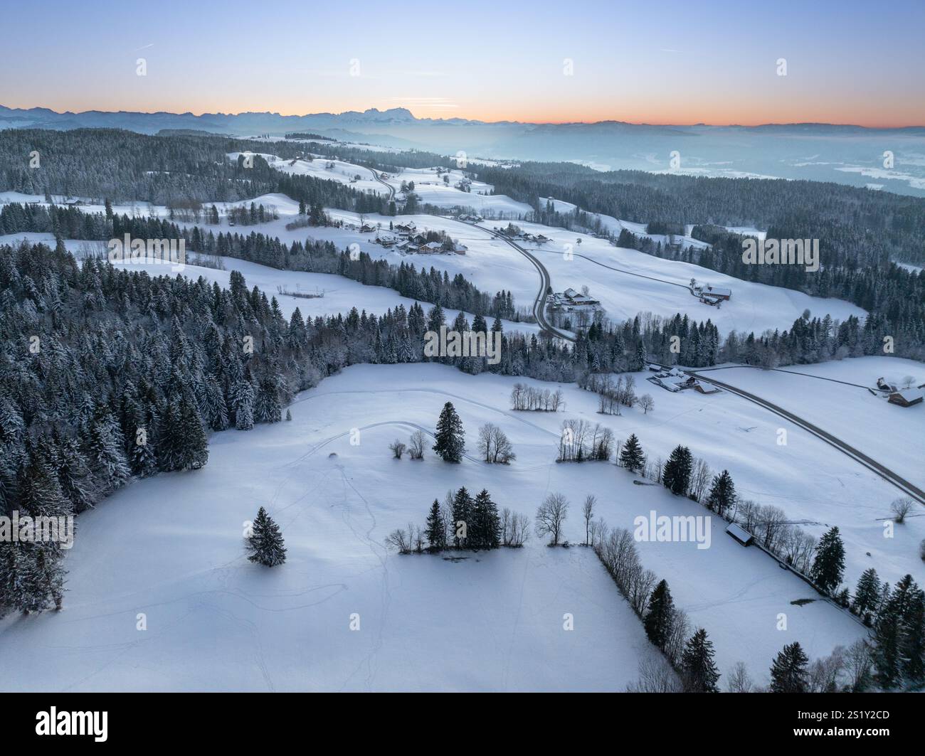 Photo aérienne de paysage enneigé dans le crépuscule du coucher de soleil dans les montagnes Allgaeu à côté d'Oberreute en Bavière, Allemagne Banque D'Images