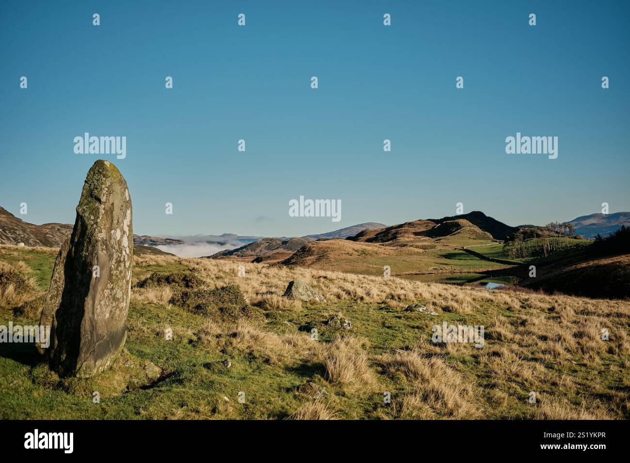 Une pierre debout surplombe les lacs de Cregennan, ou Llynnau Cregennan, près d'Arthog, Dolgellau et l'estuaire de Mawddach dans le nord du pays de Galles Banque D'Images