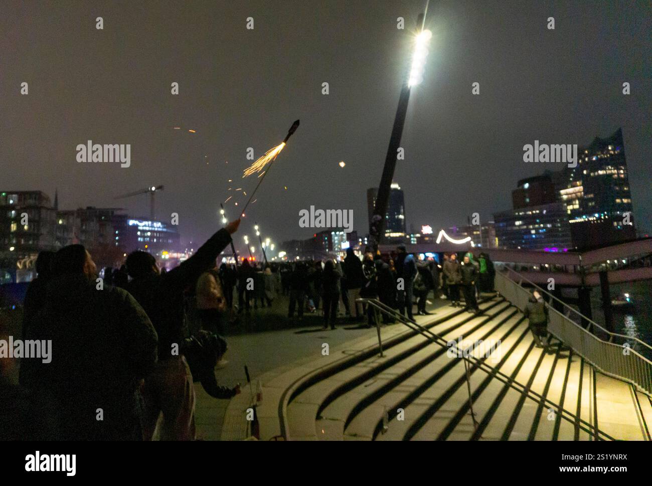 Personne laisse feu d'artifice fusée partir de la main, réveillon du nouvel an 2025 sur la promenade de l'Elbe à Hambourg, au port, sur l'Elbe, pompiers de nombreux t Banque D'Images