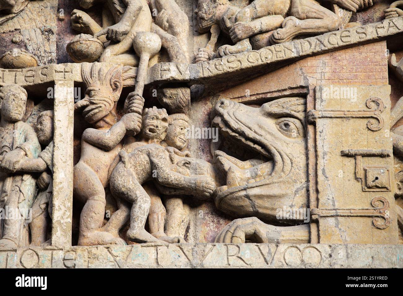 Les reliefs en pierre présentent des personnages détaillés et des événements de l'histoire, offrant un aperçu de l'art de Conques, en France. Banque D'Images