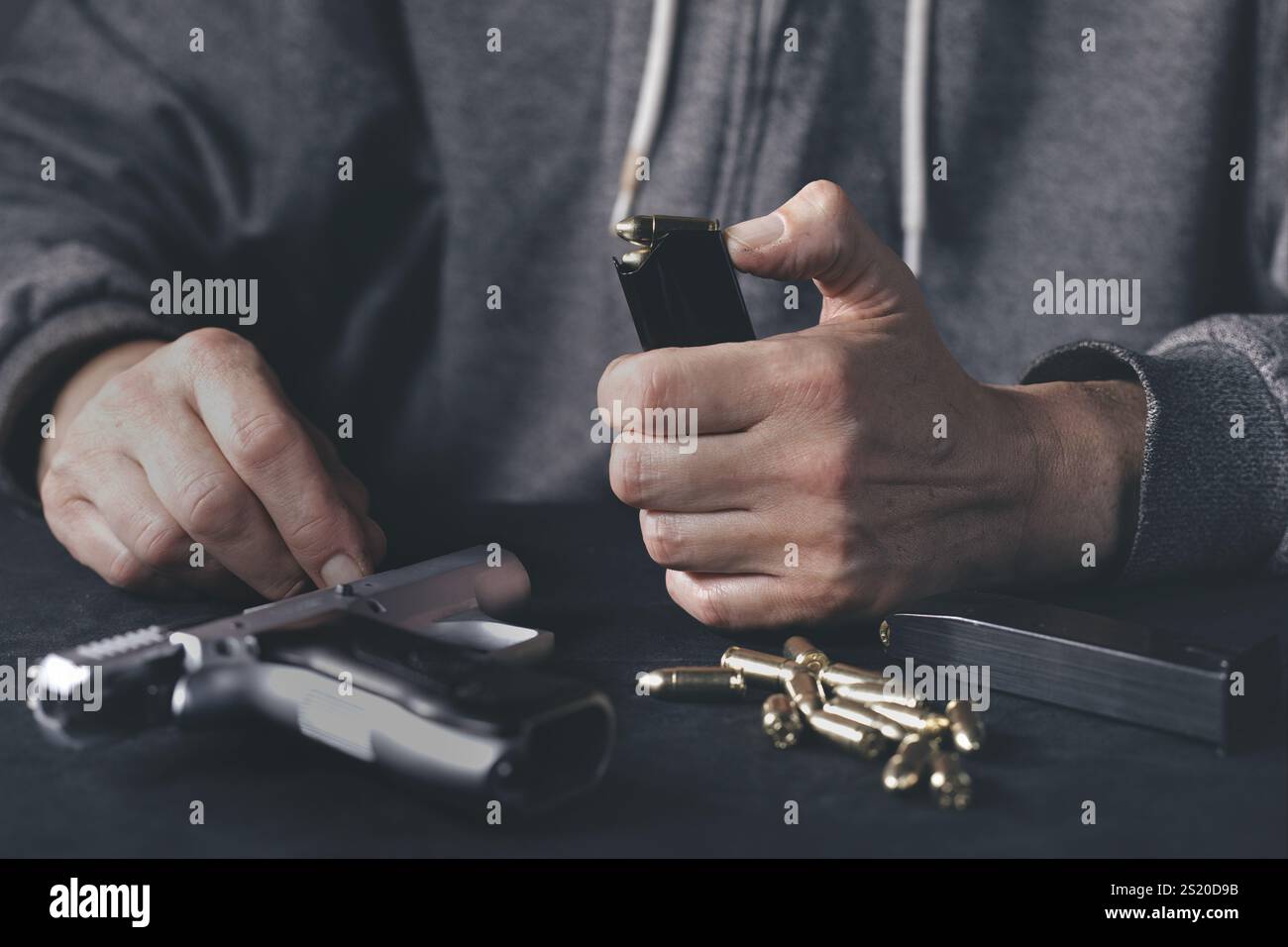 Homme chargeant mgazine de pistolet semi-automatique à la maison Banque D'Images