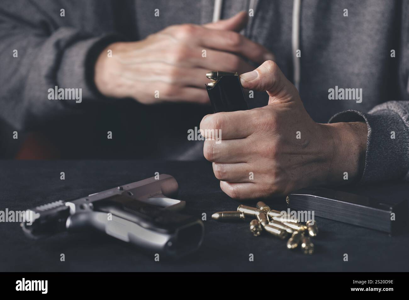 Homme chargeant mgazine de pistolet semi-automatique à la maison Banque D'Images