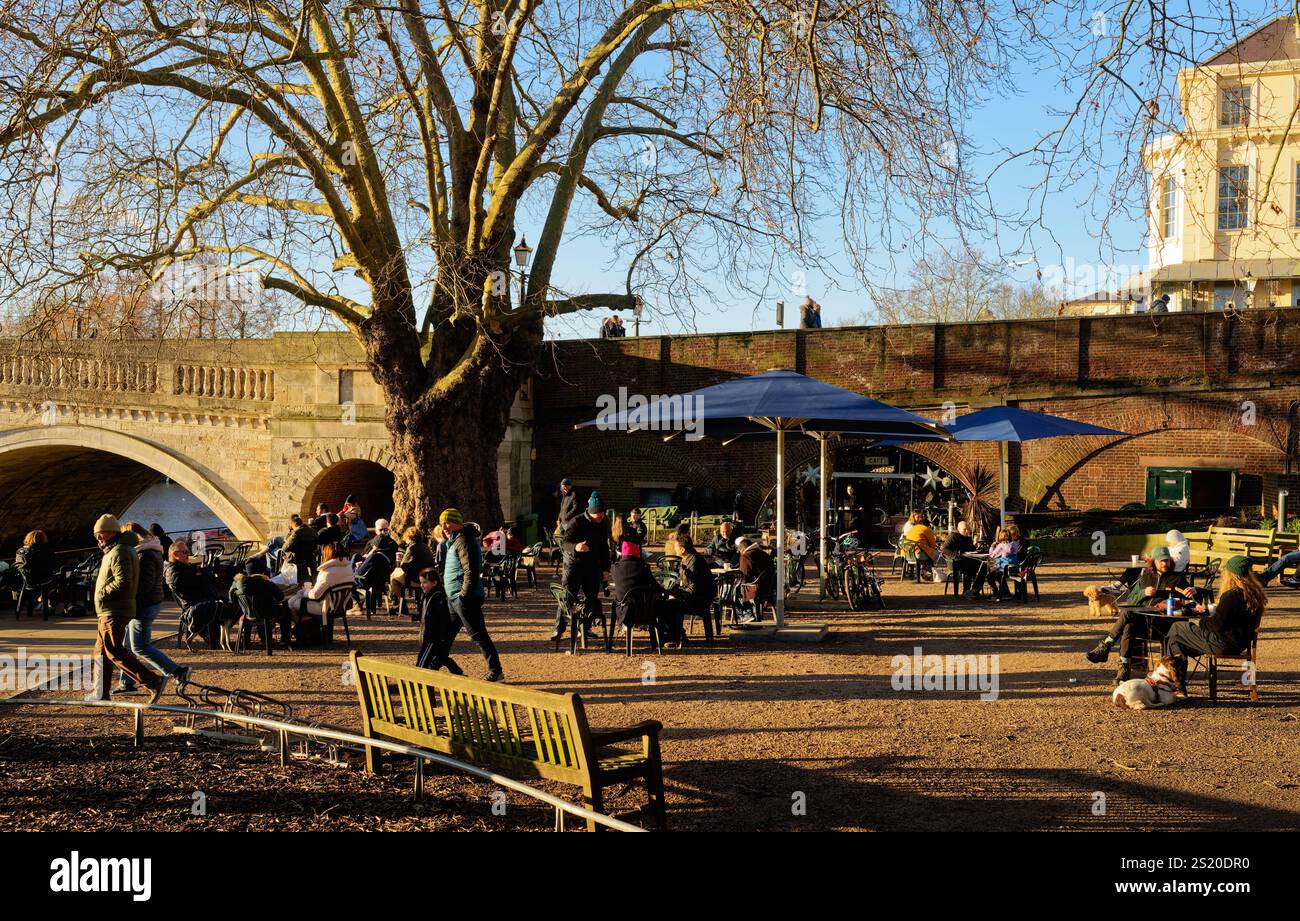 Les gens assis à des tables dans un café en plein air en hiver un jour de brèche, Richmond upon Thames, Londres, Angleterre Banque D'Images