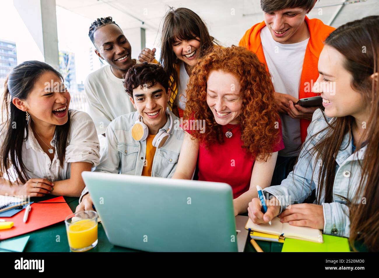 Jeune groupe d'étudiants adolescents travaillant ensemble sur ordinateur portable à l'école du campus Banque D'Images