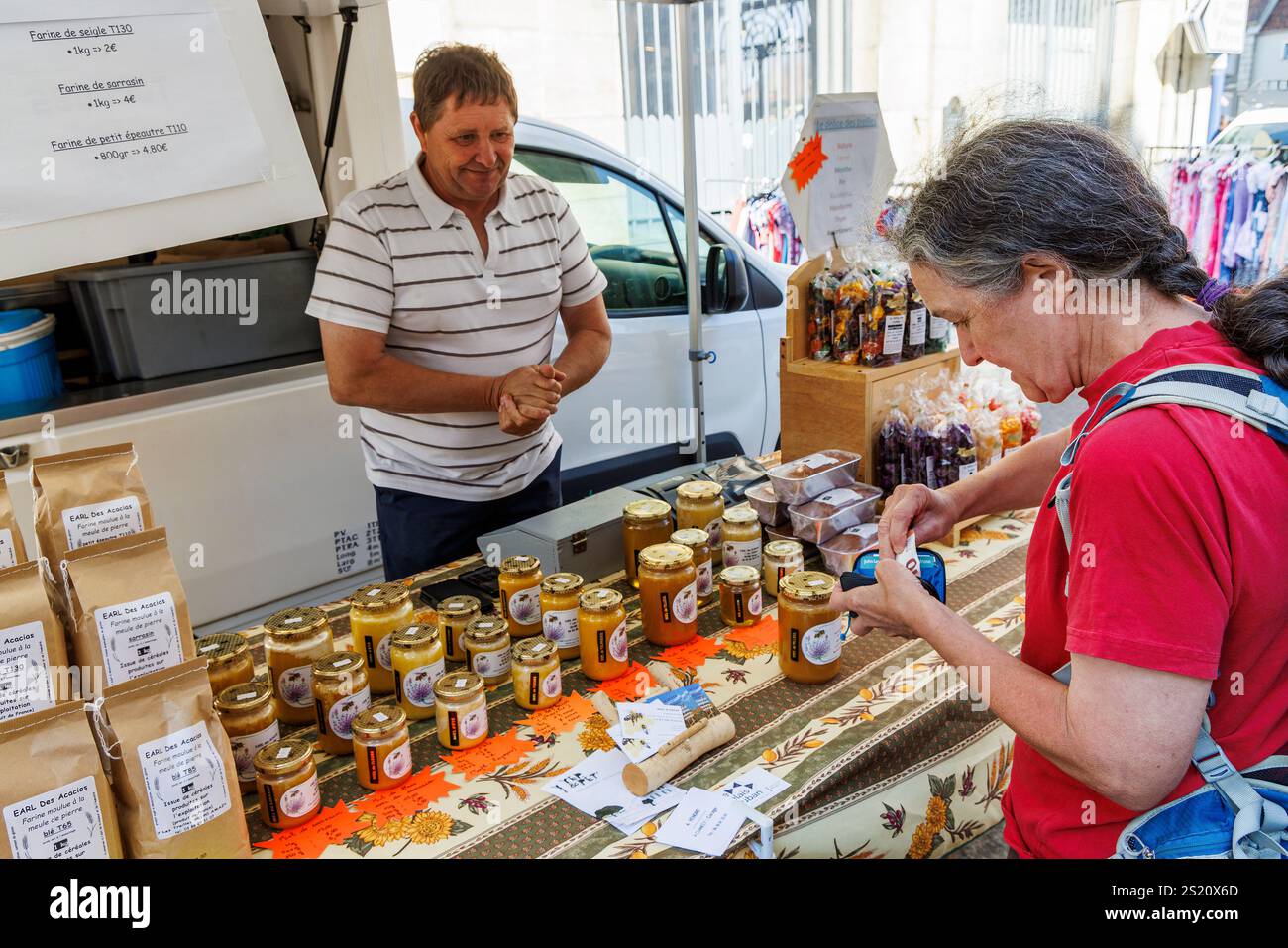 Femme achetant du miel à un étal à un marché du dimanche dans la rue. Clemacy, France Banque D'Images
