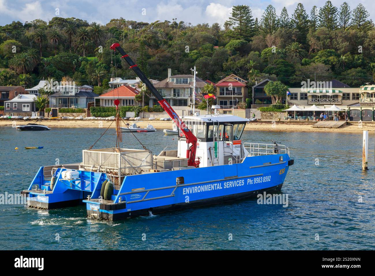 Un bateau de services environnementaux utilisant une cage pour enlever les ordures de l'eau à Watsons Bay, Sydney, Australie Banque D'Images