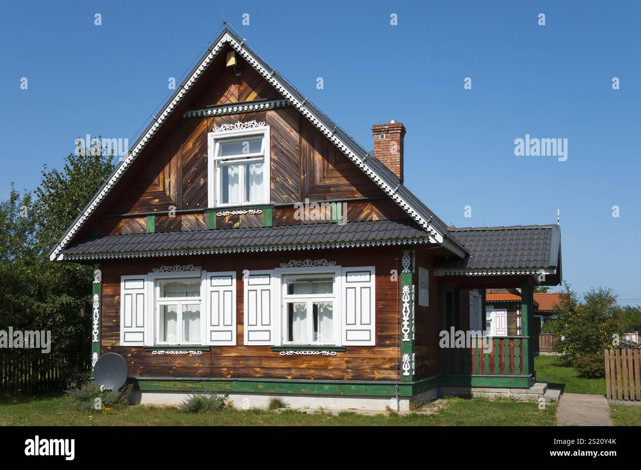 Maison traditionnelle en bois avec décorations et antenne parabolique dans le jardin verdoyant, Budy, BiaNowieZa, Bialowieza, Podlaskie Voivodeship, Podlaskie, po Banque D'Images