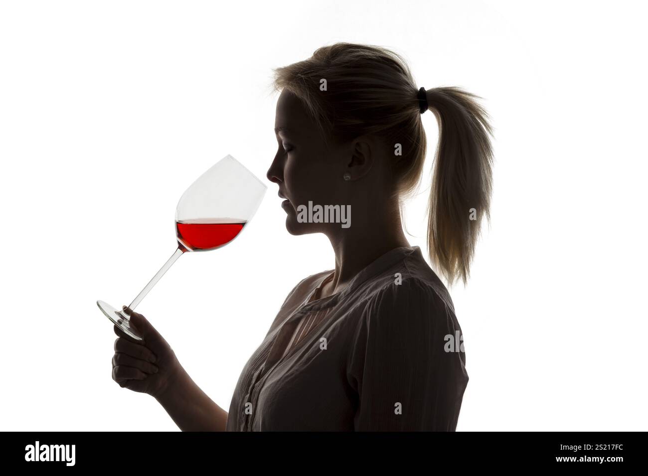 Une jeune femme à une dégustation de vin. Dégustation d'un verre de vin rouge dans un verre de vin rouge Banque D'Images
