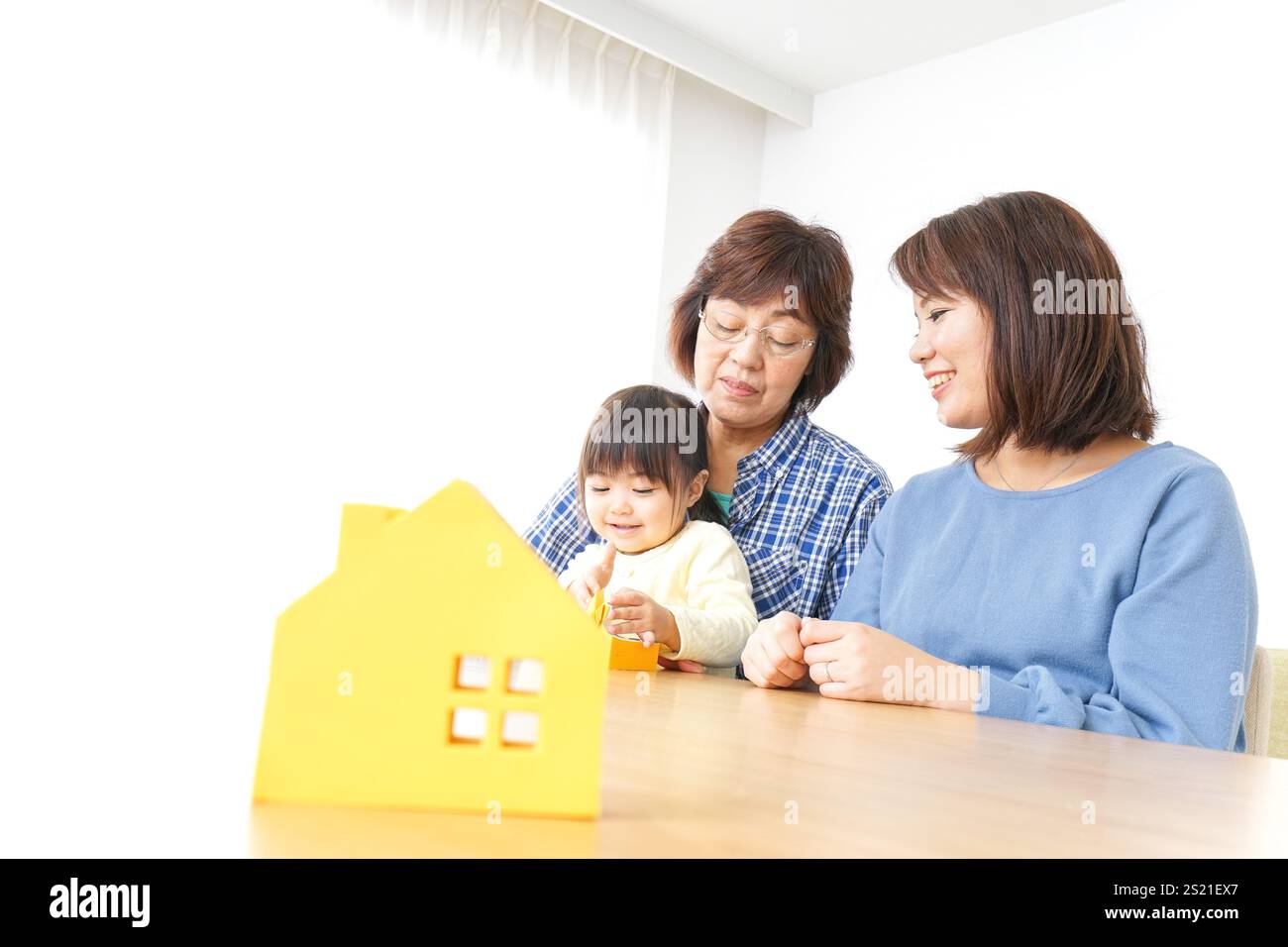 Trois générations trouvant une image de maison Banque D'Images